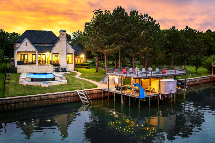 Twilight aerial view of the lakefront villa, infinity pool and private dock