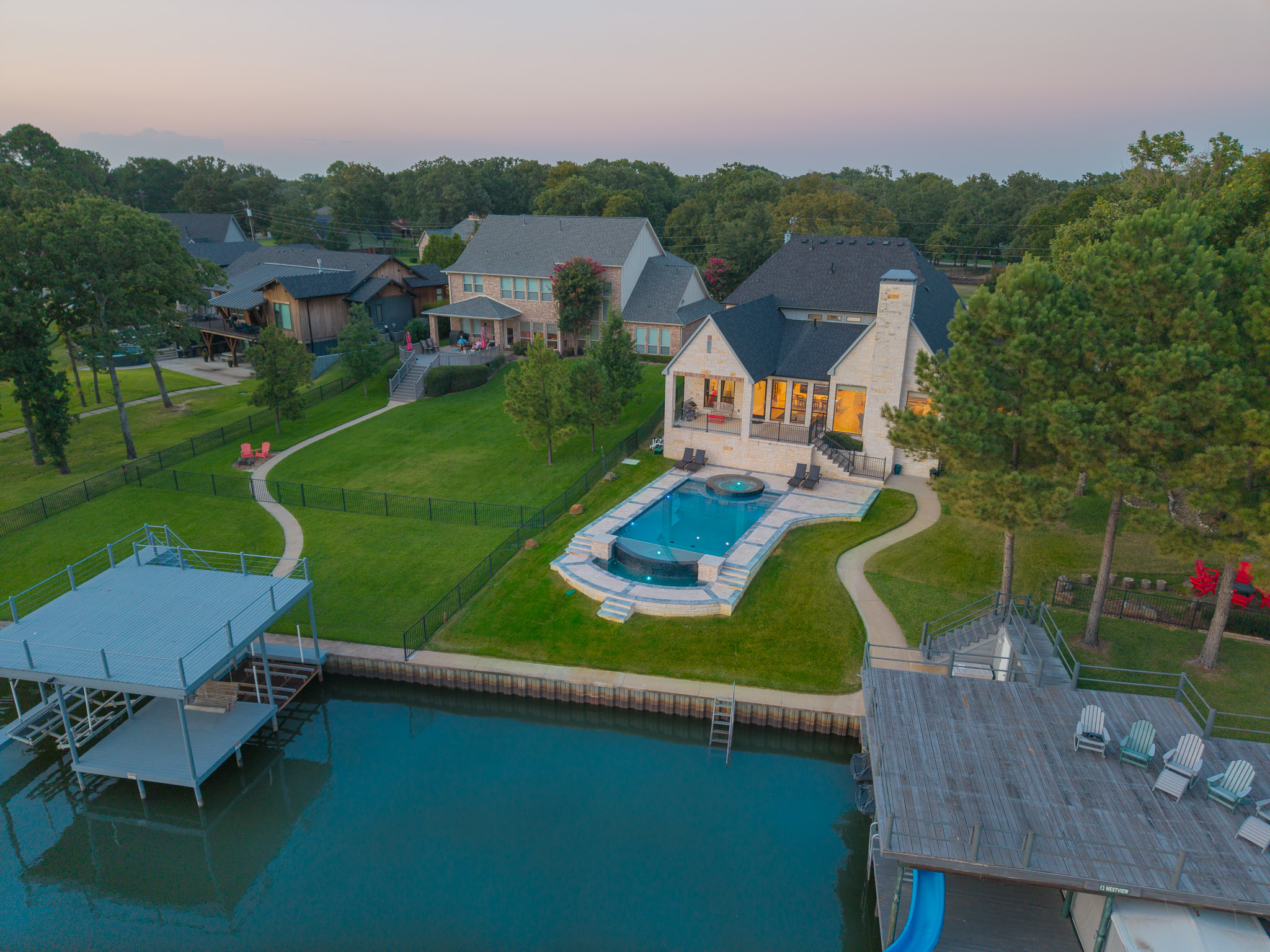Twilight aerial view of the lakefront villa, infinity pool, private dock and Cedar Creek Lake